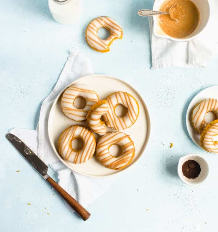         Description: Unique donuts on a plate with icing and a knife.