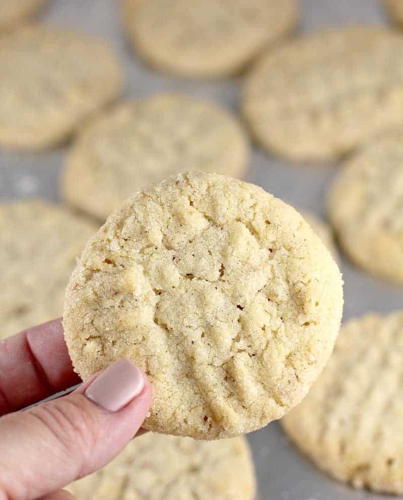 A person displaying a unique peanut butter cookie on a baking sheet.