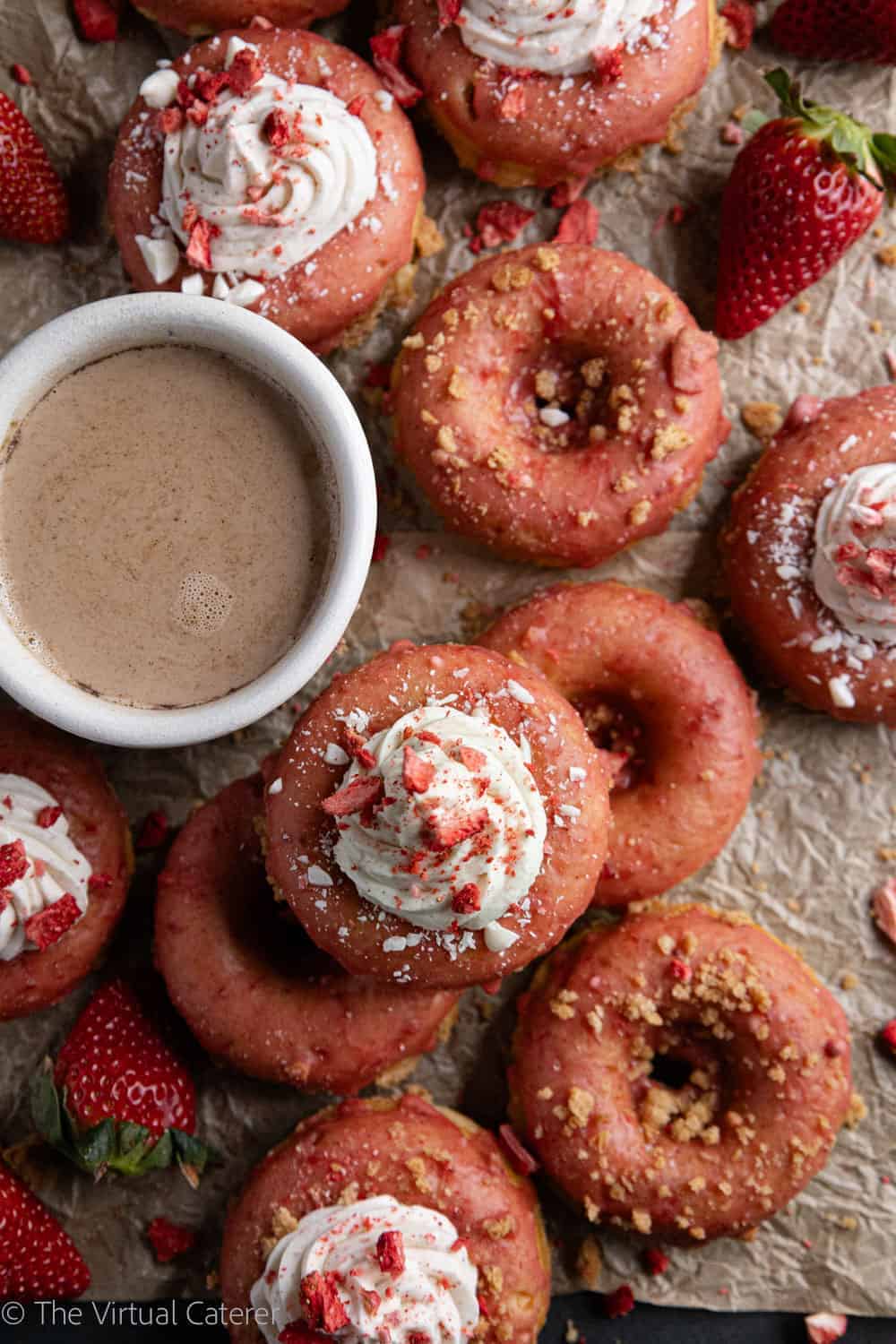 Unique strawberry donuts topped with whipped cream and sprinkles.