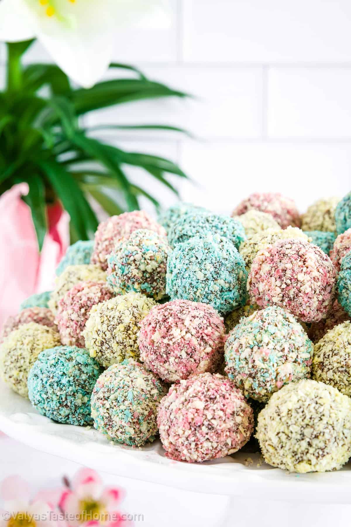 Unique Easter truffles on a white plate with flowers in the background.