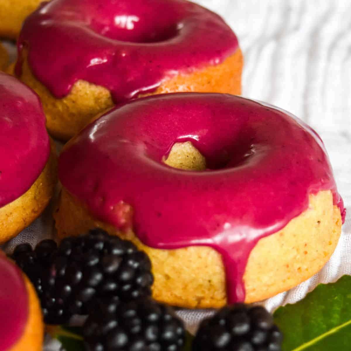 Unique blackberry donuts with icing and blackberries.