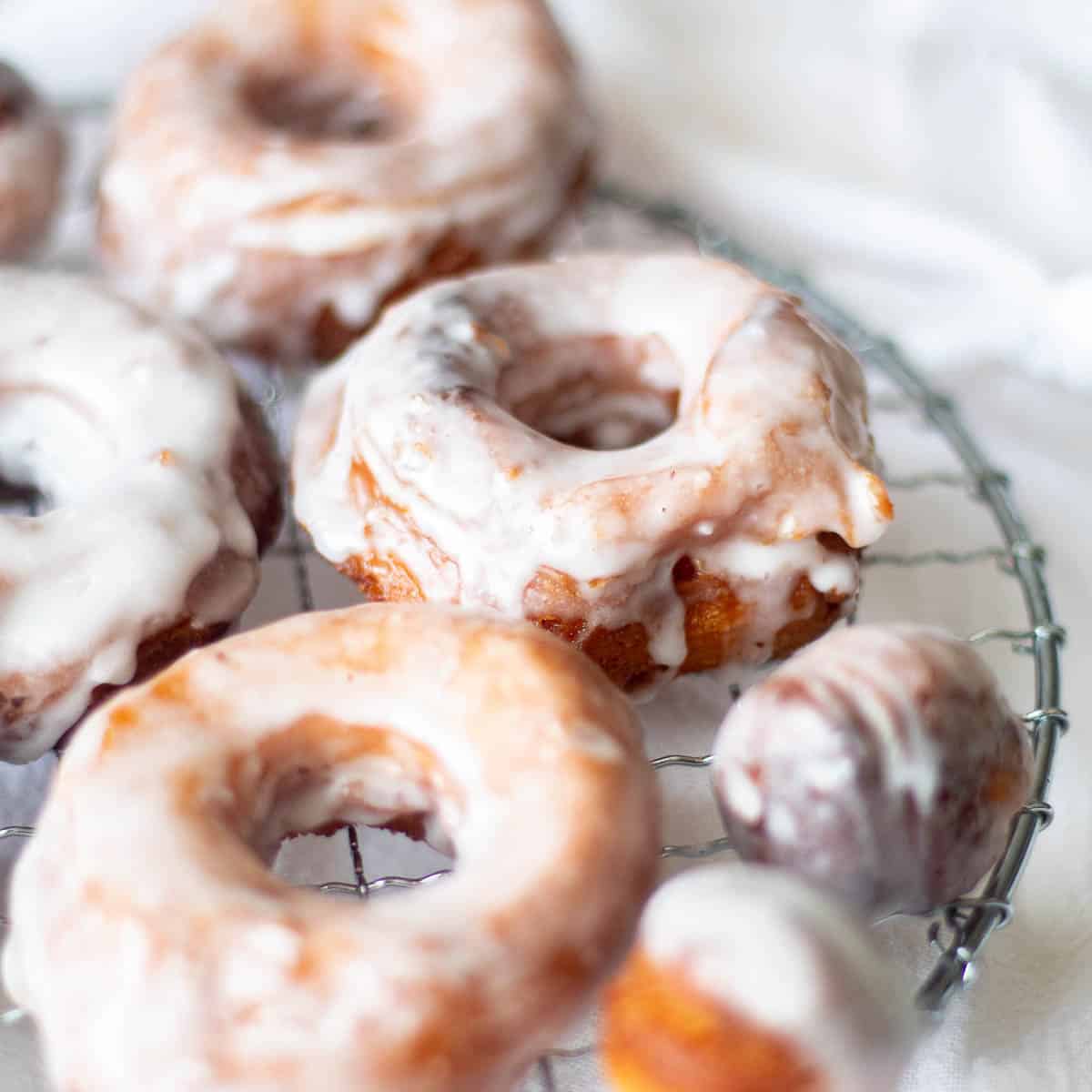 Glazed donuts with unique flavors on a wire rack.