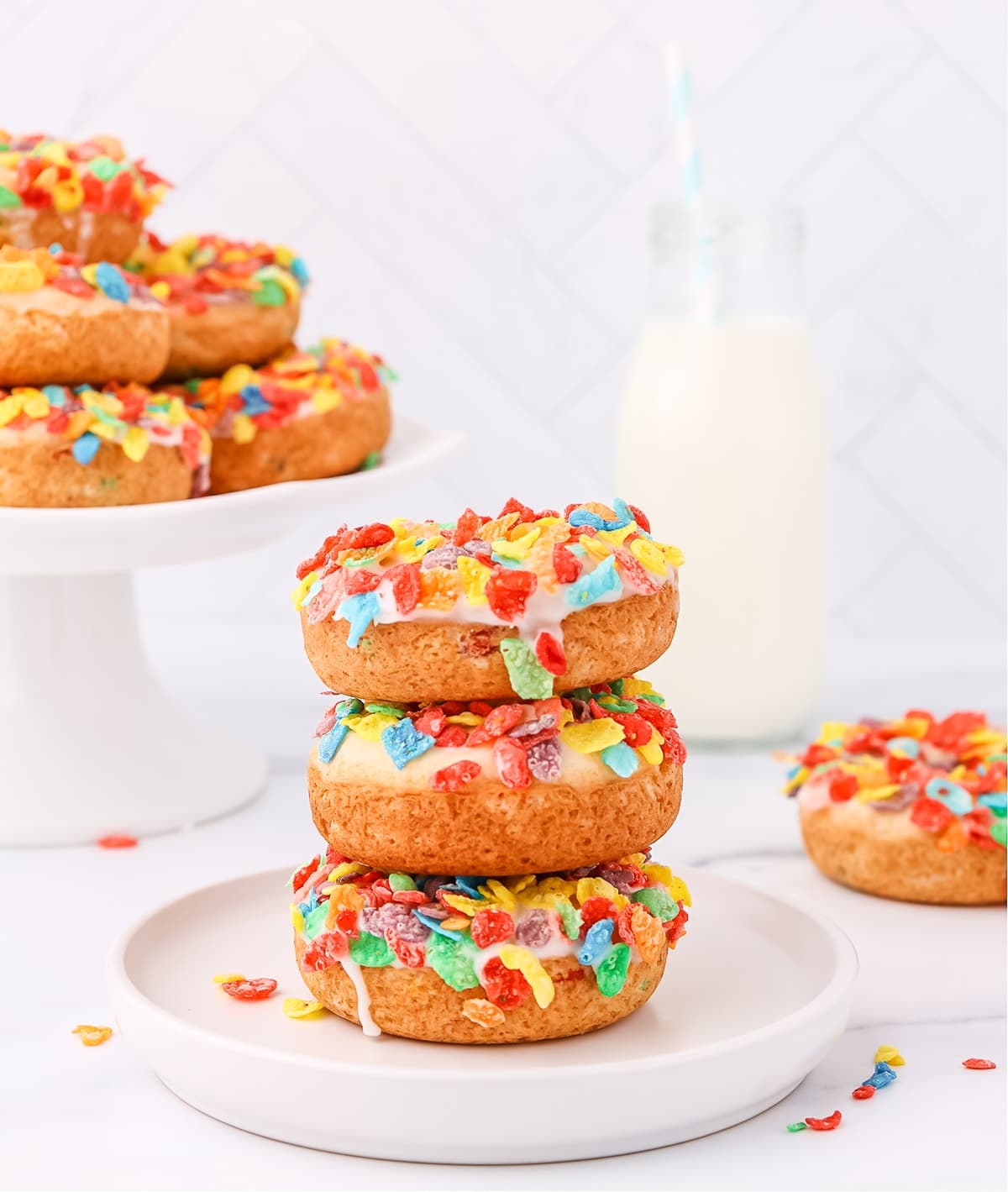 A stack of unique donuts with sprinkles on top.