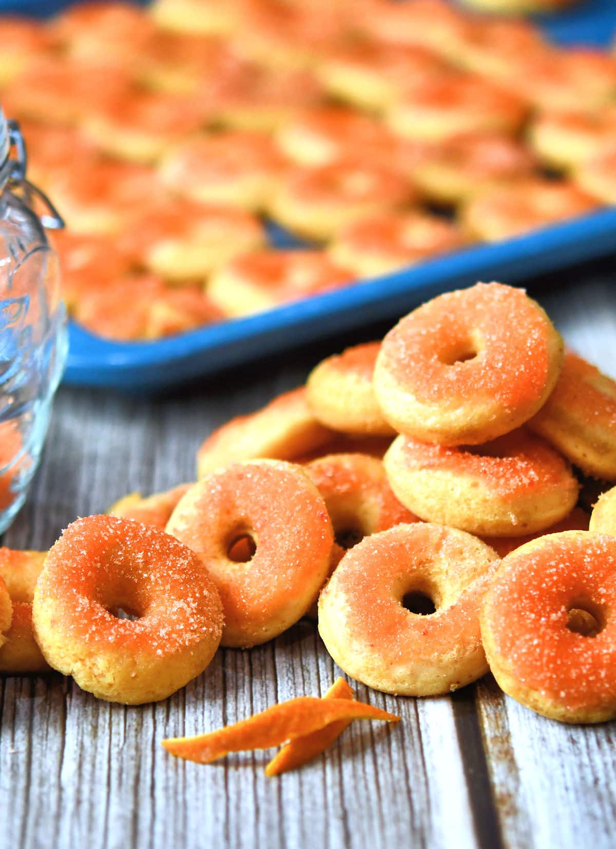 Unique orange sugar donuts on a wooden table.