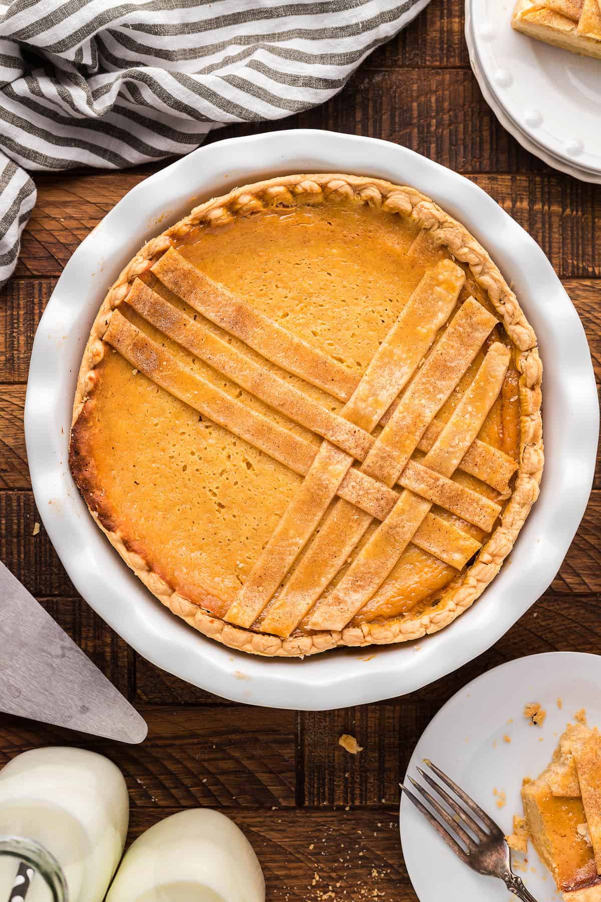 A pumpkin pie with a slice taken out of it, resembling a Sweet Italian ricotta pie. 
