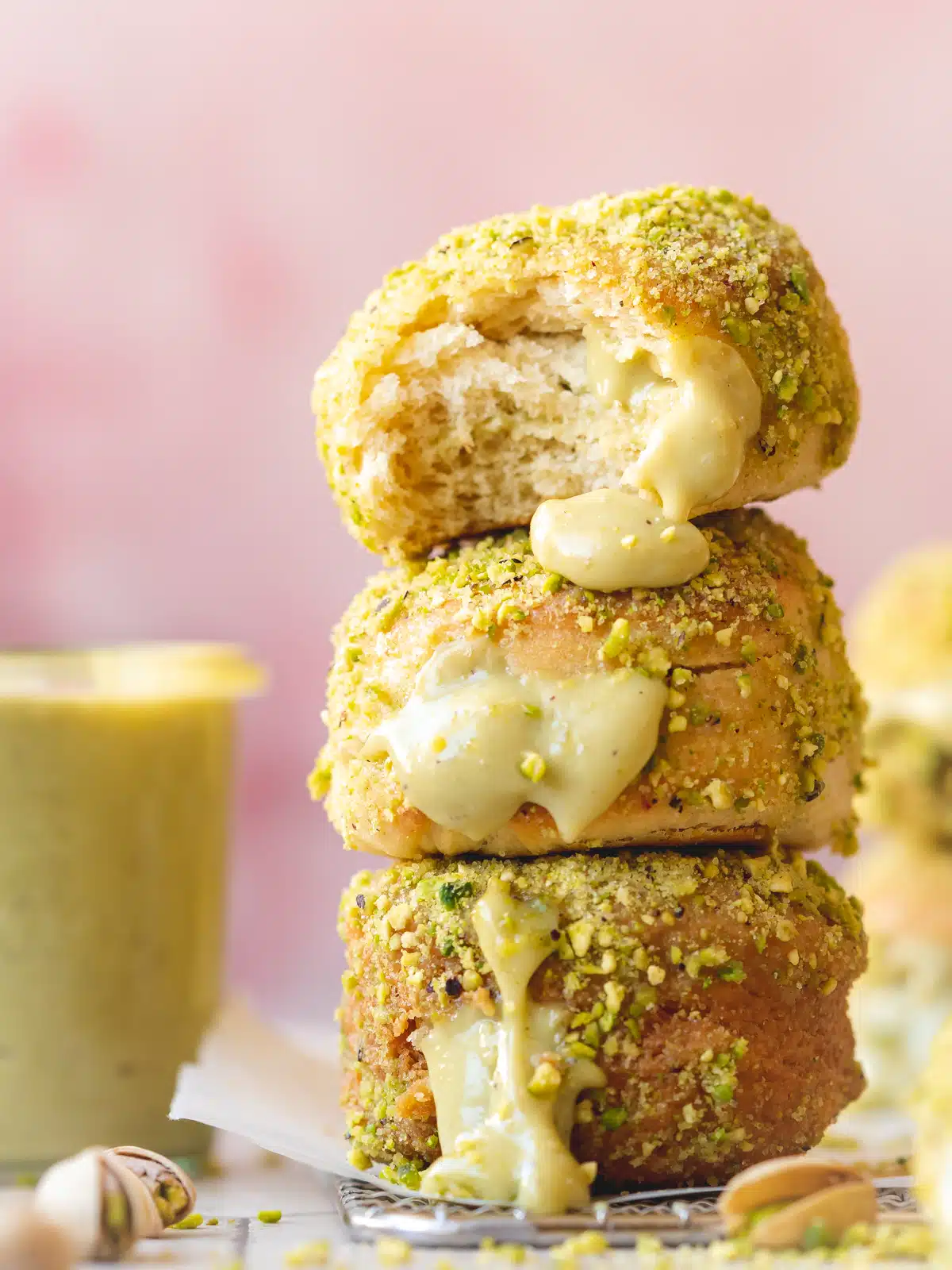 A stack of pistachio doughnuts topped with pistachio sauce, showcasing unique donut flavors.