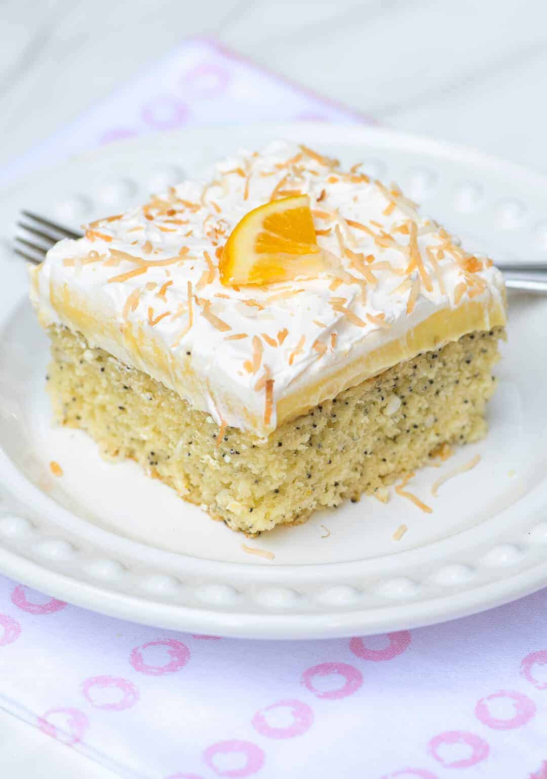 A piece of Lemon Coconut Poppy Seed Cake on a white plate. 
