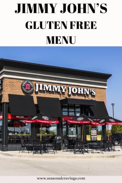 An exterior view of a Jimmy John's restaurant promoting a gluten-free menu, with red umbrellas outside under a clear sky.