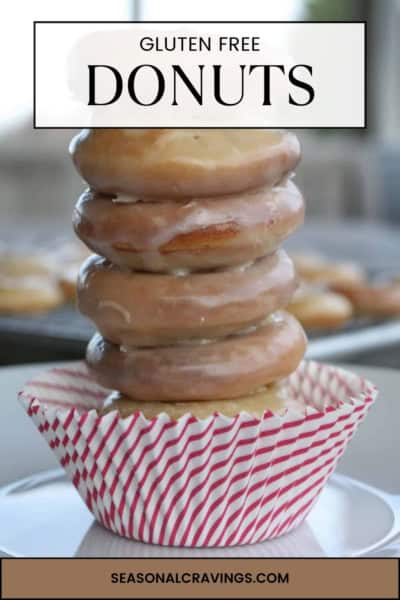 A stack of five glazed doughnuts labeled "Gluten Free" placed in a red and white striped cupcake liner on a plate, with the text "seasonalcravinging.COM" at the bottom. These gluten free doughnuts (Krispy Kreme Copycat) are perfect for satisfying your sweet tooth!